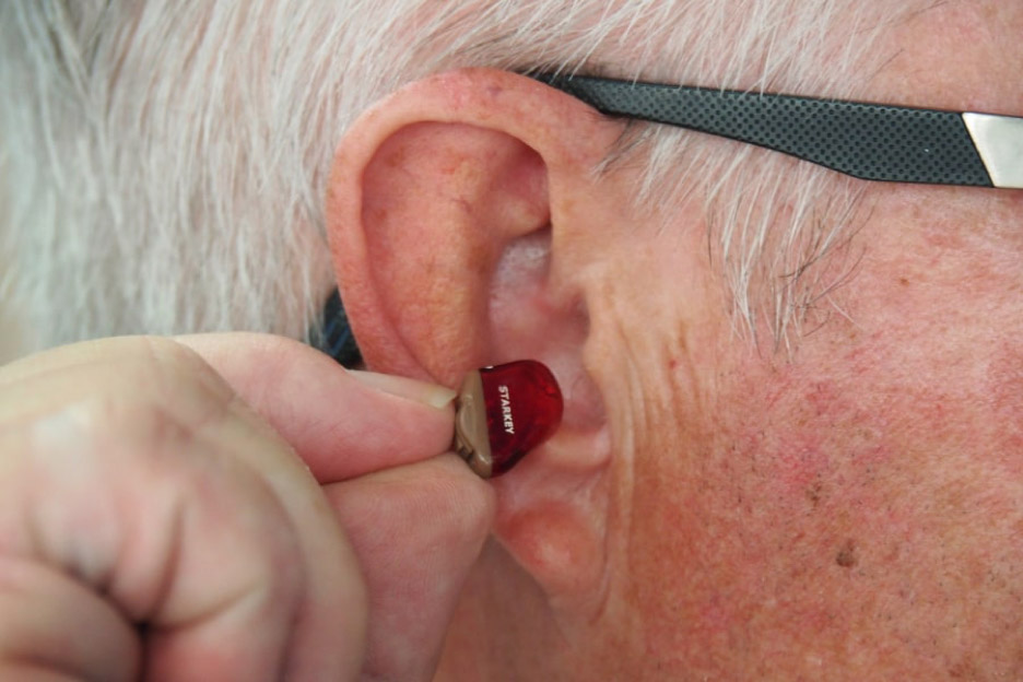 Närbild på ett öra med hörapparat